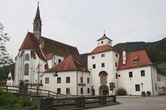 an old white church with red roof and steeples on the side of it's building