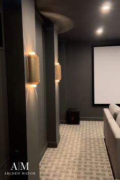 an empty room with two couches and a projector screen in the middle of it