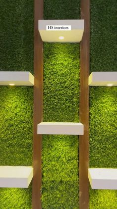 an artificial grass wall is shown with shelves and lights on each shelf, along with the words it's interior