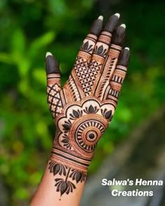 a woman's hand with henna designs on it and the words salwa's henna creations