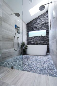 a bathroom with stone walls and flooring, including a large bathtub next to a walk in shower