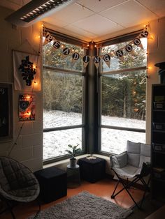 a living room filled with furniture and windows covered in christmas lights next to a snow covered forest