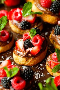 small pastries with fresh berries and mint sprinkled on them