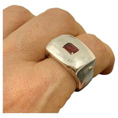 Bold, modern, sculptural, chunky garnet and sterling silver signet statement ring by Lebanese designer Rosa Maria. Marks: Rosa Maria, 925 for Sterling Silver Size: 8.5 Weight: 29.8 grams Condition: Very Good, light surface wear, nice patina Ring Face: 22mm by 15mm Garnet: 6mm by 4mm, emerald cut, lively burgundy Provenance: from the collection of a noted NYC psychiatrist and collector of unusual, often one-of-a-kind jewels. This sophisticated, modern Rosa Maria signet ring centers an emerald cut European Jewelry, Silver Horse, Gold Ring Designs, Silver Signet Ring, Gold Signet Ring, Garnet Stone, Modern Ring, Organic Form, Jewelry Inspo