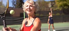 an older woman is playing tennis on the court with her racket and ball in front of her