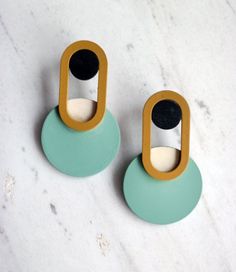 two wooden and plastic objects sitting on top of a white counter