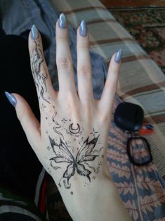 a woman's hand with a butterfly tattoo on it