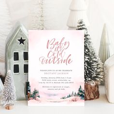 a pink and white christmas party with trees, houses, and snow on the ground