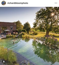 an outdoor swimming pool in front of a house with the sun shining down on it