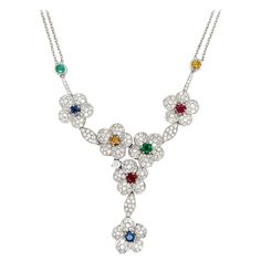 This show-stopping necklaces showcases 6 beautiful diamonds flowers with ruby, emerald, blue and yellow sapphire center stones set in 18 karat white gold. Measuring at about 16" longs this necklace is sure to make the right statement no matter the occasion. Total Weights Diamond 3.60cts Sapphire 0.65cts Ruby 0.61cts Emeralds 0.28cts 1stdibs Jewelry, Diamond Flower Necklace, Lariat Style Necklace, Sapphire Necklace Pendants, Emerald Blue, Ruby Emerald, Ruby Necklace, Gold Diamond Necklace, Modern Necklaces