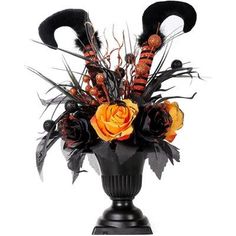 a black vase filled with flowers and feathers