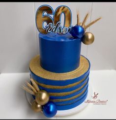 a blue and gold 50th birthday cake with decorations