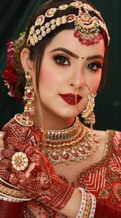 a woman with red makeup and jewelry on her face