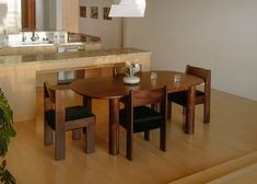 a kitchen table with chairs and a potted plant on top of it in front of the counter