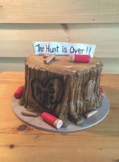 a cake made to look like a tree stump with writing on it that says the hunt is over