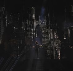 a man standing on top of a set of stairs in front of a dark city