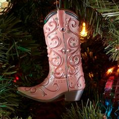 a pink cowboy boot ornament hanging from a christmas tree