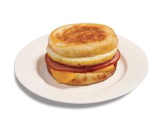 a white plate topped with a sandwich on top of a pancake covered in cheese