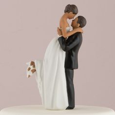 a bride and groom figurine on top of a white cake with brown spots