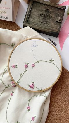 a cross stitch pattern on a white cloth next to a wooden box