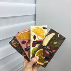 a person holding four different types of fruit bars