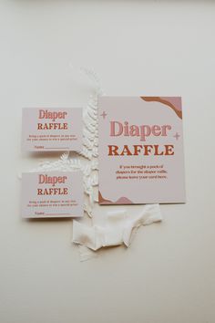 three diaper raffle labels on a white surface