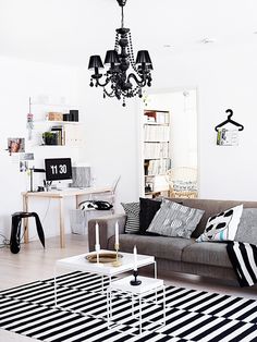 a living room filled with furniture and a chandelier hanging over the top of it