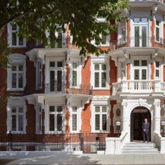 a large red brick building with white trim and balconies on the second floor