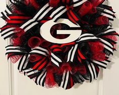 a black and red wreath with the letter g on it