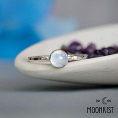 This lovely bezel-set solitaire stacking ring, promise ring, or statement ring features a colorful 6 mm round rainbow moonstone cabochon, set in sterling silver. This June Birthstone is the perfect gift for your ever-changing darling...the colors swirl and dance across the stone, which looks different in different lights. Due to the nature of rainbow moonstone, individual pieces vary in color, (and the same piece may look different in different lighting!) but I make a special effort to select pi Handmade Minimalist Moonstone Promise Ring, White Stackable Moonstone Rings With Ethical Gemstones, Handmade Moonstone Stackable Rings For Promise, Stackable Moonstone Promise Ring With Round Stone, Everyday Stackable Moonstone Ring, Minimalist Moonstone Stackable Rings As Gifts, Gift Stackable Rings With Moon Phase Design, Minimalist Moon-shaped Moonstone Ring For Gift, Minimalist Moon Shaped Moonstone Ring As Gift