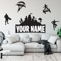 a living room with a white couch and black wall decal that says your name