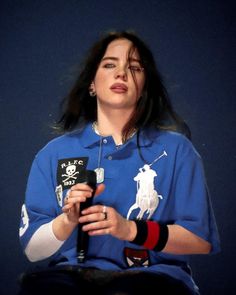 a woman in a blue shirt holding a cell phone