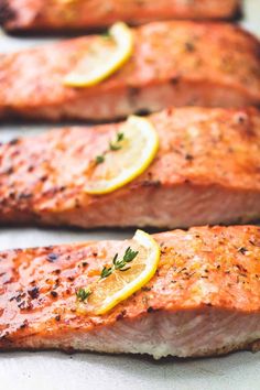 four salmon fillets with lemon slices and herbs