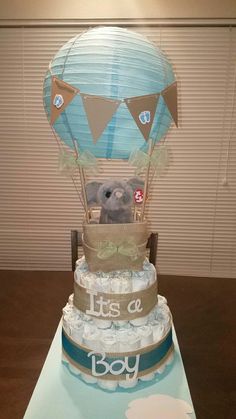 a baby shower cake with a teddy bear in the middle and it's a boy on top