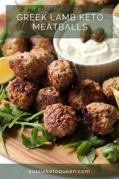 greek lamb keto meatballs on a wooden platter with lemon wedges and garnish