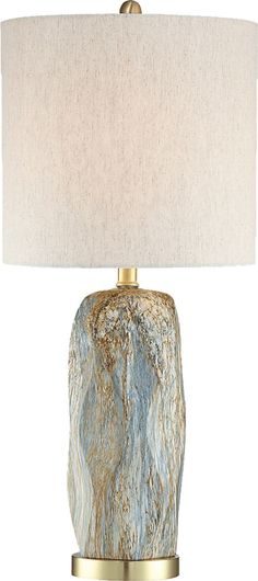 a table lamp with a white shade on the base and a gold metal frame around it