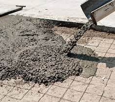 cement being poured onto the ground by a shovel