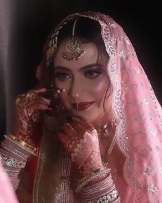 a woman in a bridal outfit posing for the camera with her hands on her face