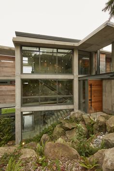 an exterior view of a modern house with rocks and plants