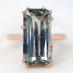 Main StoneType: Mined, Natural | SapphireHardness: 9/10, hardest of colored gemsShape: Emerald CutCut: Brilliant CutCarat weight: 10.75Dimensions: 18.65mm long x 9.3mm wide x 5.55mm deep - (Printable Gem Size Chart - go by the diamet... Green And Periwinkle, Bicolor Sapphire, Contour Wedding Band, Alternative Bridal, Claw Prong, Colored Gems, Green Sapphire, Periwinkle Blue, Natural Sapphire