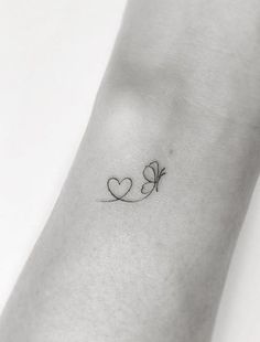 a small heart tattoo on the wrist