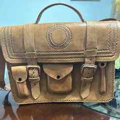 Genuine And Decorated Leather Briefcase, Camel Color, Unisex, Medium Size; It Can Be Carried By Hand Or Hung On The Shoulder, Two Divisions Inside. New Without Tags Casual Light Brown Leather Satchel, Travel Satchel With Leather Lining In Camel, Camel Satchel With Leather Lining For Travel, Classic Camel Rectangular Satchel, Beige Rectangular Satchel With Leather Backing, Casual Leather Rectangular Briefcase, Casual Camel Leather Shoulder Bag, Beige Leather Satchel Briefcase, Camel Leather Satchel For Travel