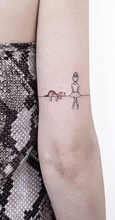 a woman's arm with a small tattoo of two cats and a dog on it