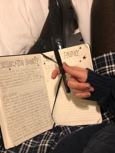 a person holding an open book with writing on it next to a pair of black shoes