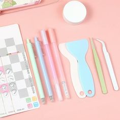 various stationery items laid out on a pink surface