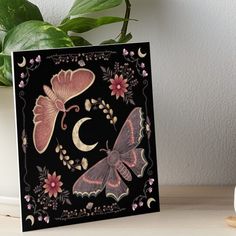 a black and pink card with butterflies on it art board print by the letter c