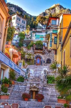 an old town with stairs leading up to the top and flowers growing on the bottom