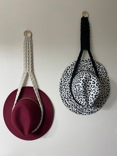 two hats hanging on the wall next to each other