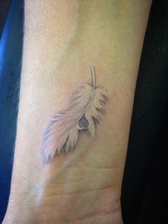 a small feather tattoo on the wrist