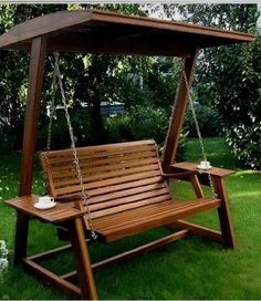 a wooden swing bench in the grass